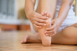 close up of woman holding foot